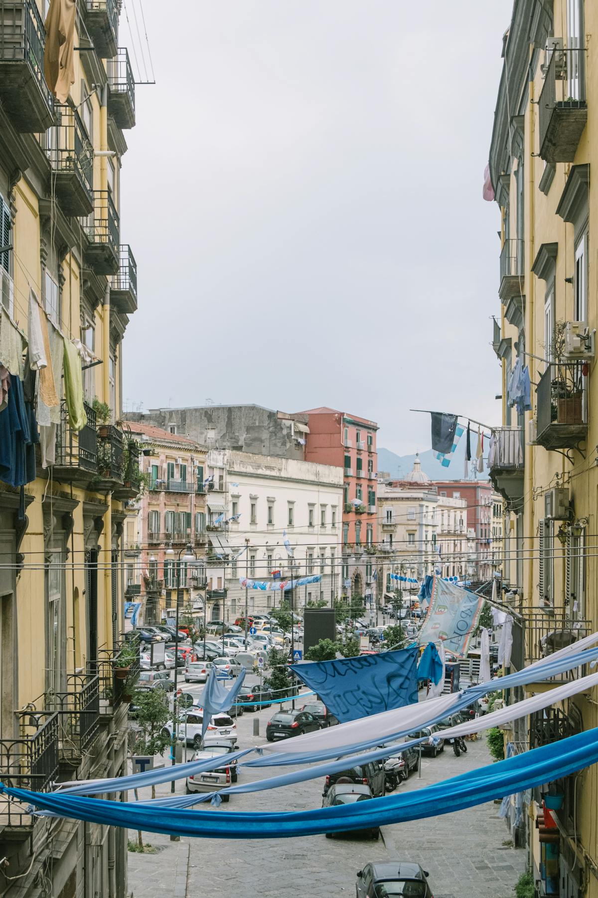 A narrow street in Naples with historic architecture on both sides