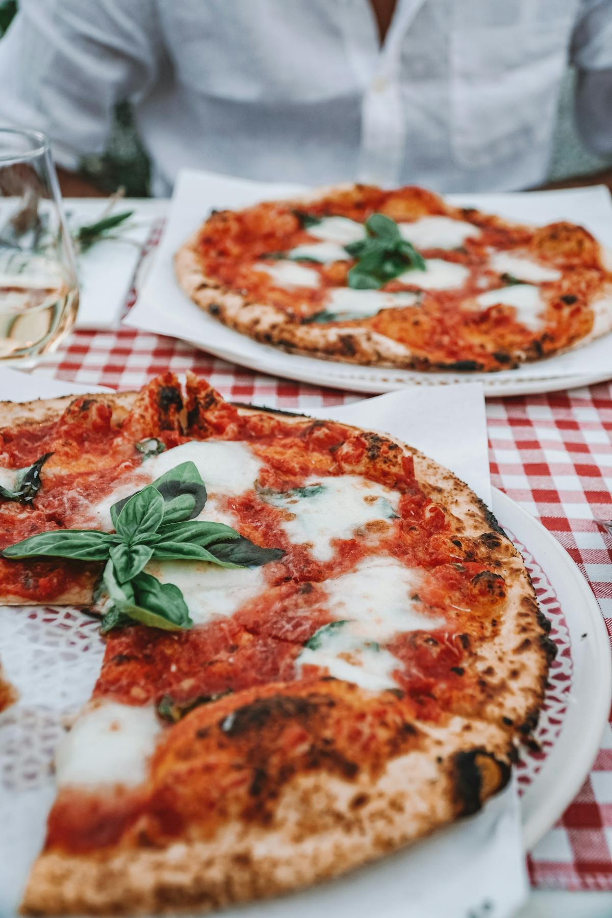 Margherita pizza on a red checkered tablecloth