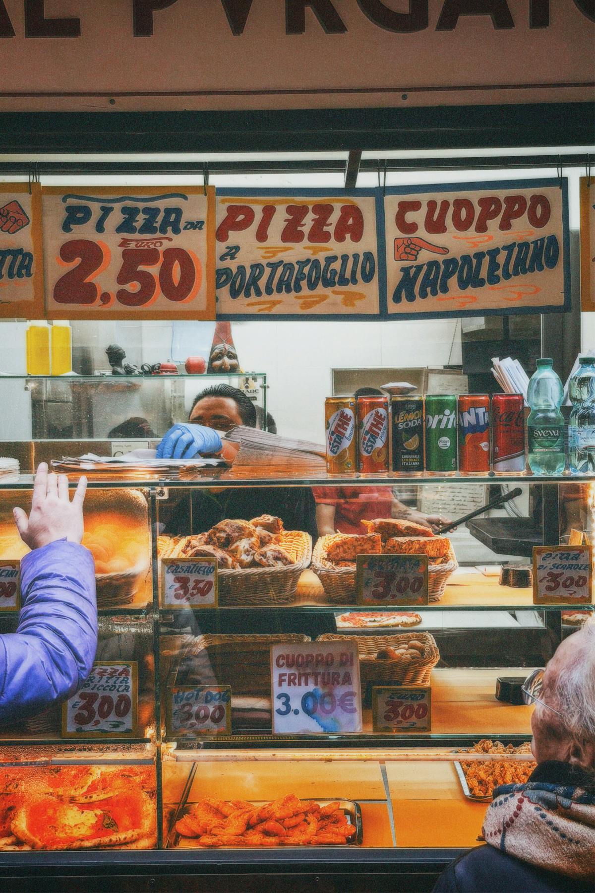 Italian street food stall in Naples offering pizza and traditional fried snacks