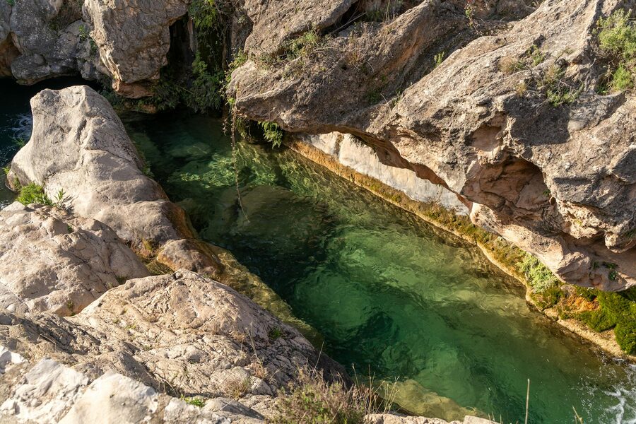 Natural rock pool with clear water among rocky formations in Bolbaite Spain