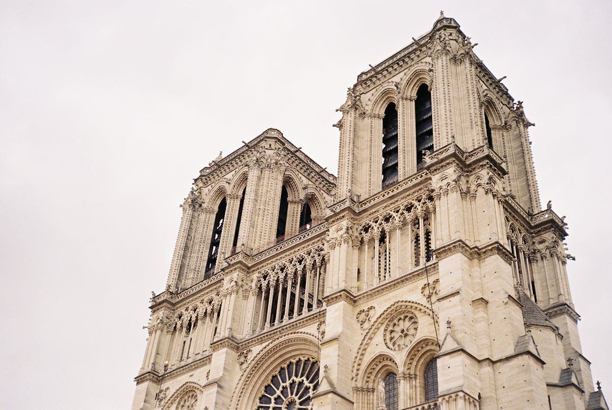 Close-up of the Notre-Dame Cathedral bell tower showing intricate Gothic stone tracery and pointed arches