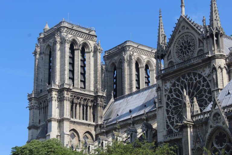 The west facade of Notre-Dame Cathedral in Paris showing the twin bell towers and detailed Gothic stone carvings