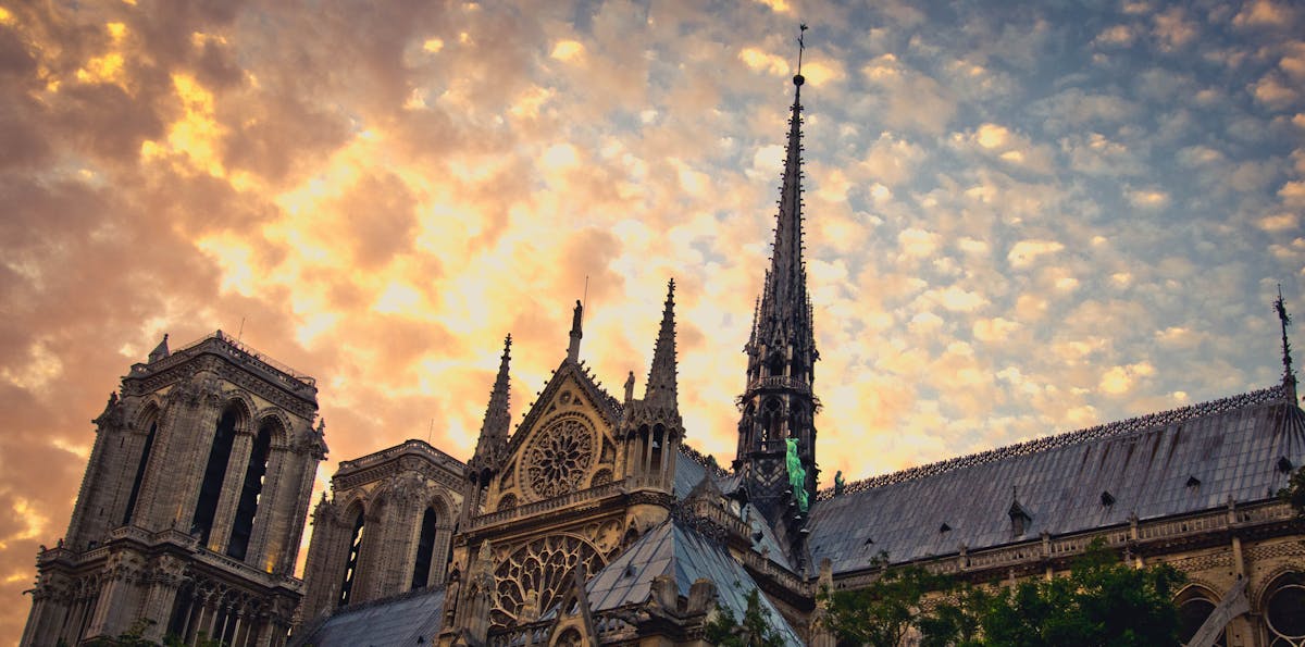 Sunset view of Notre-Dame Cathedral in Paris with warm golden light illuminating the Gothic facade