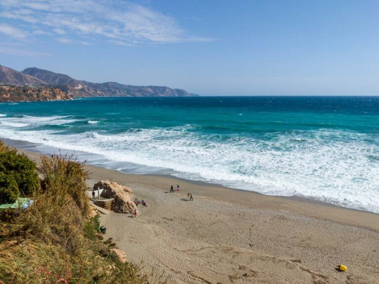Aerial shot of Nerja coastline showing turquoise Mediterranean waters and sandy beach