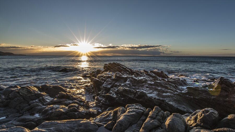 Golden sunrise over a rocky beach in Nerja with the Mediterranean Sea and cliff formations
