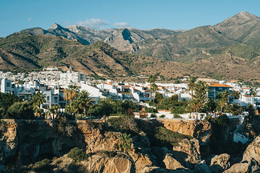 Panoramic view of Nerja white buildings against a mountainous backdrop in Andalusia
