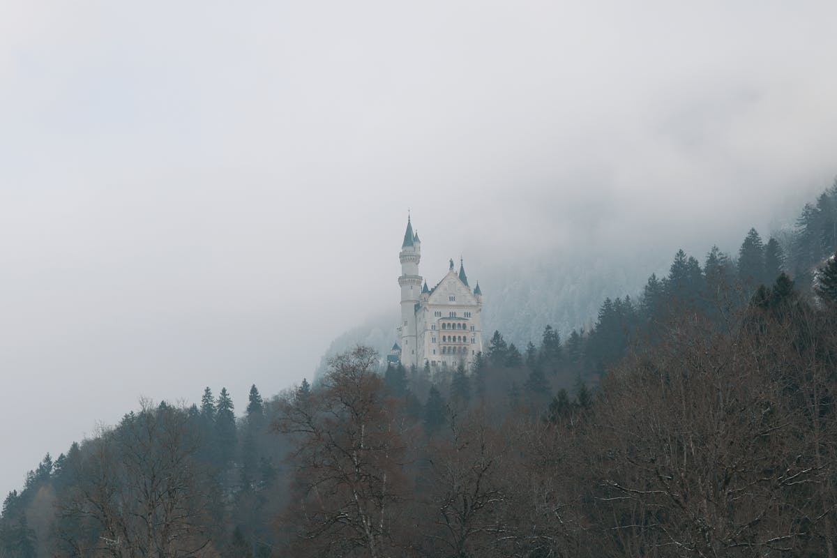 Neuschwanstein Castle partially hidden by winter fog rolling through the Bavarian hills