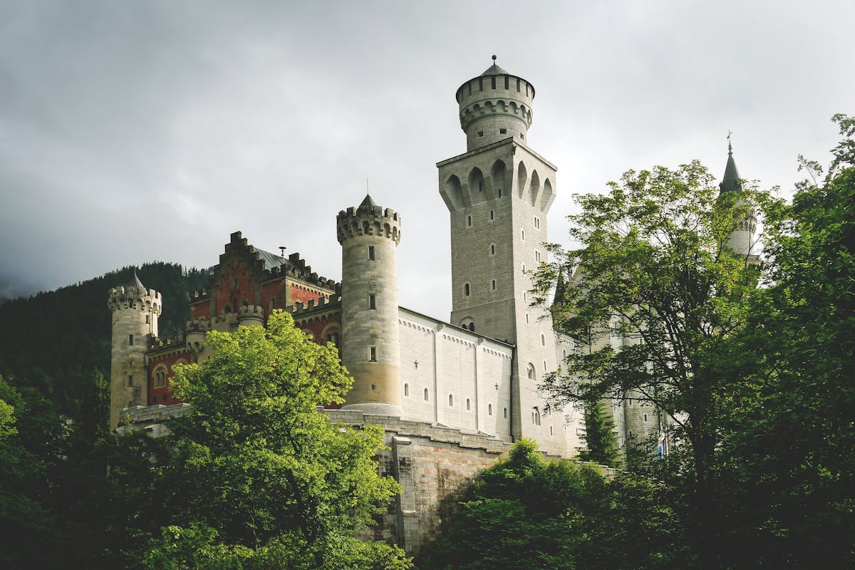 Neuschwanstein Castle in summer surrounded by deep green forests in Bavaria