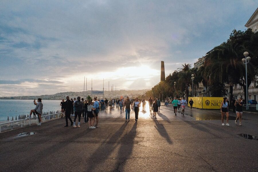 Golden sunset over the Promenade des Anglais in Nice with people walking