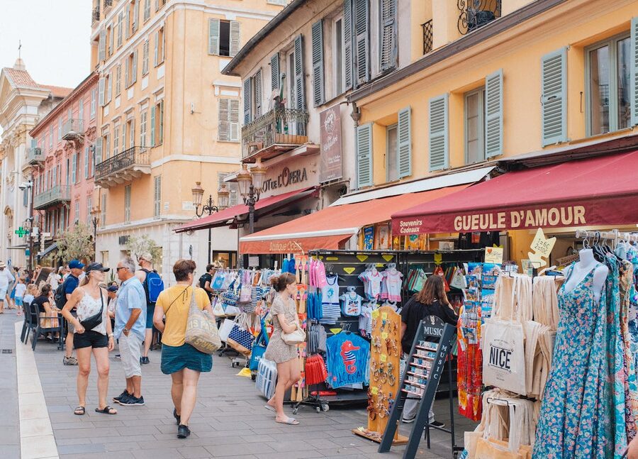 Busy street market scene in Nice old town with shoppers and colourful storefronts