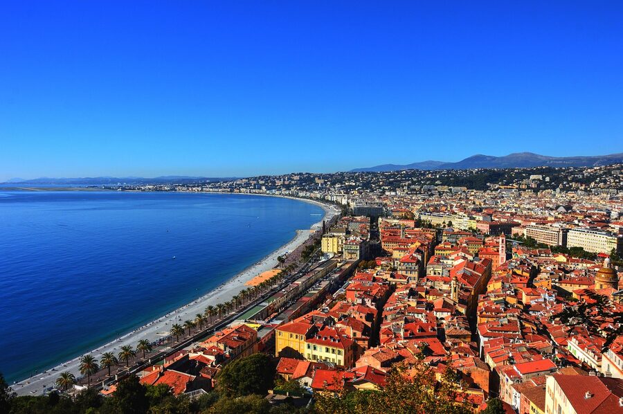 Wide boulevard of the Promenade des Anglais in Nice with palm trees and seaside views