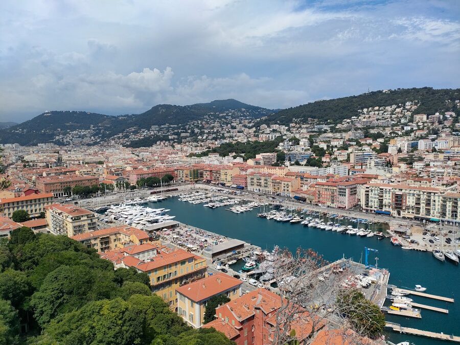 Aerial view of Nice harbour with colourful buildings and mountains in background