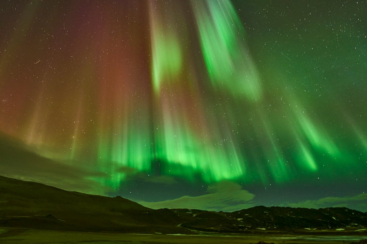 Aurora borealis dancing over an Icelandic landscape at night