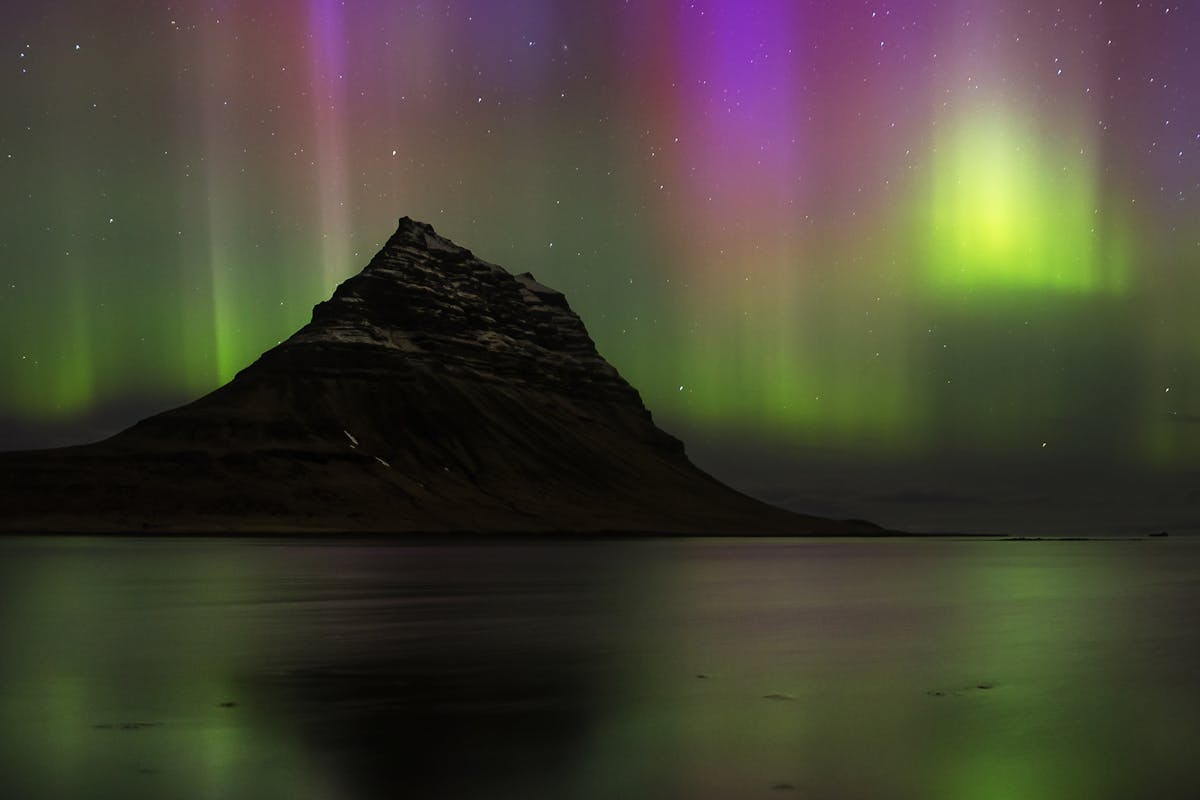 Vivid northern lights over Kirkjufell mountain in Iceland