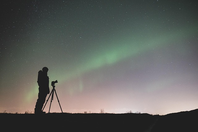 Photographer silhouette capturing the aurora borealis in Iceland
