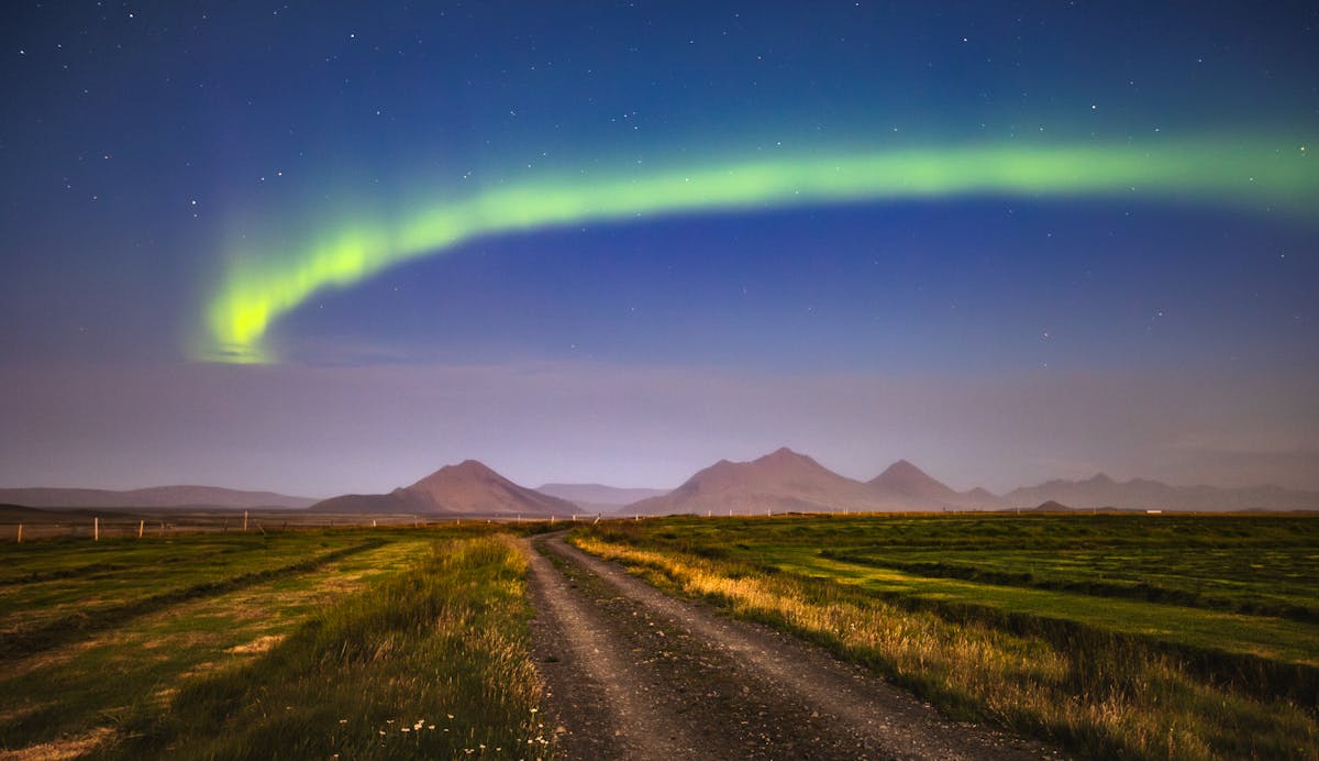 Northern lights over an Icelandic rural road at night