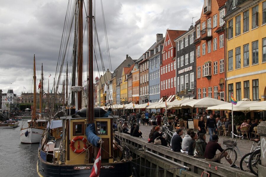 Boats moored along Nyhavn canal with colorful row houses in Copenhagen Denmark
