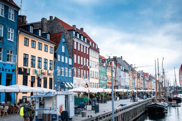 Colorful buildings and boats along Nyhavn waterfront canal in Copenhagen Denmark