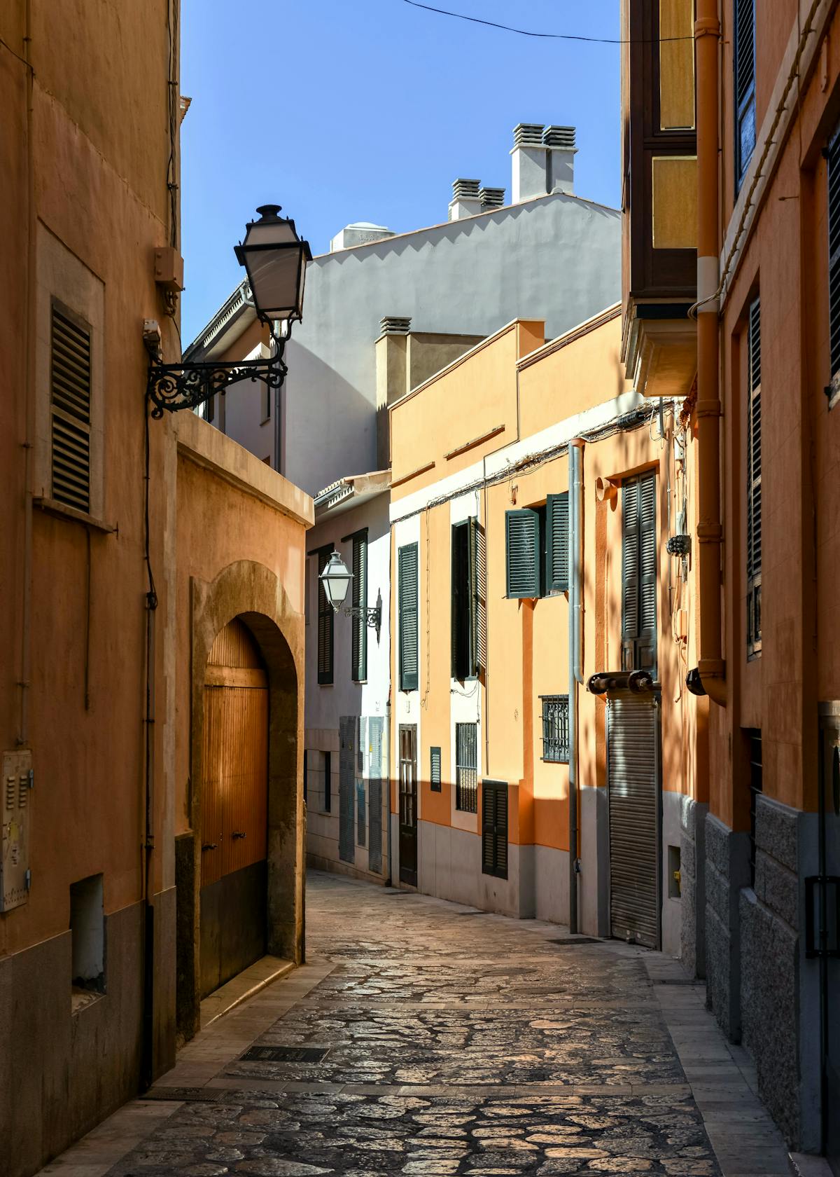 Colorful narrow alleyway with bright painted buildings and cobblestones in Palma Mallorca old quarter