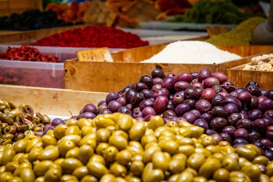 Bins of fresh green and black olives at an outdoor French market