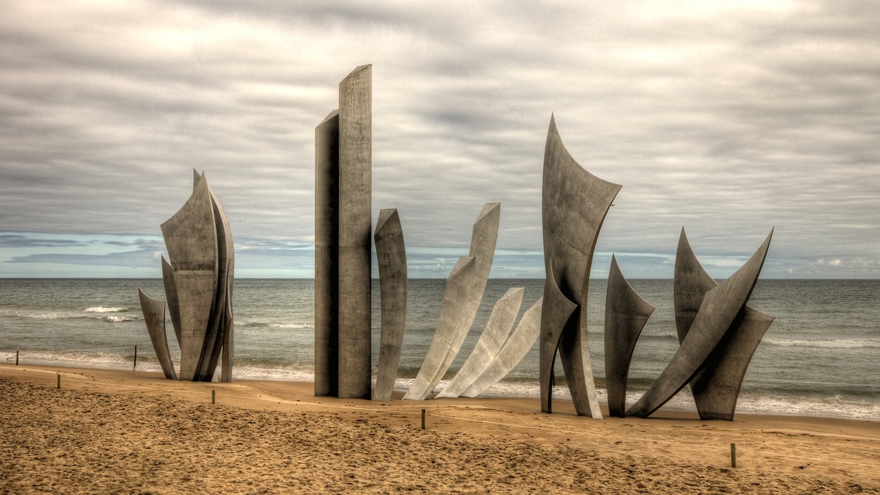 The Les Braves sculpture rising from the sand on Omaha Beach in Normandy