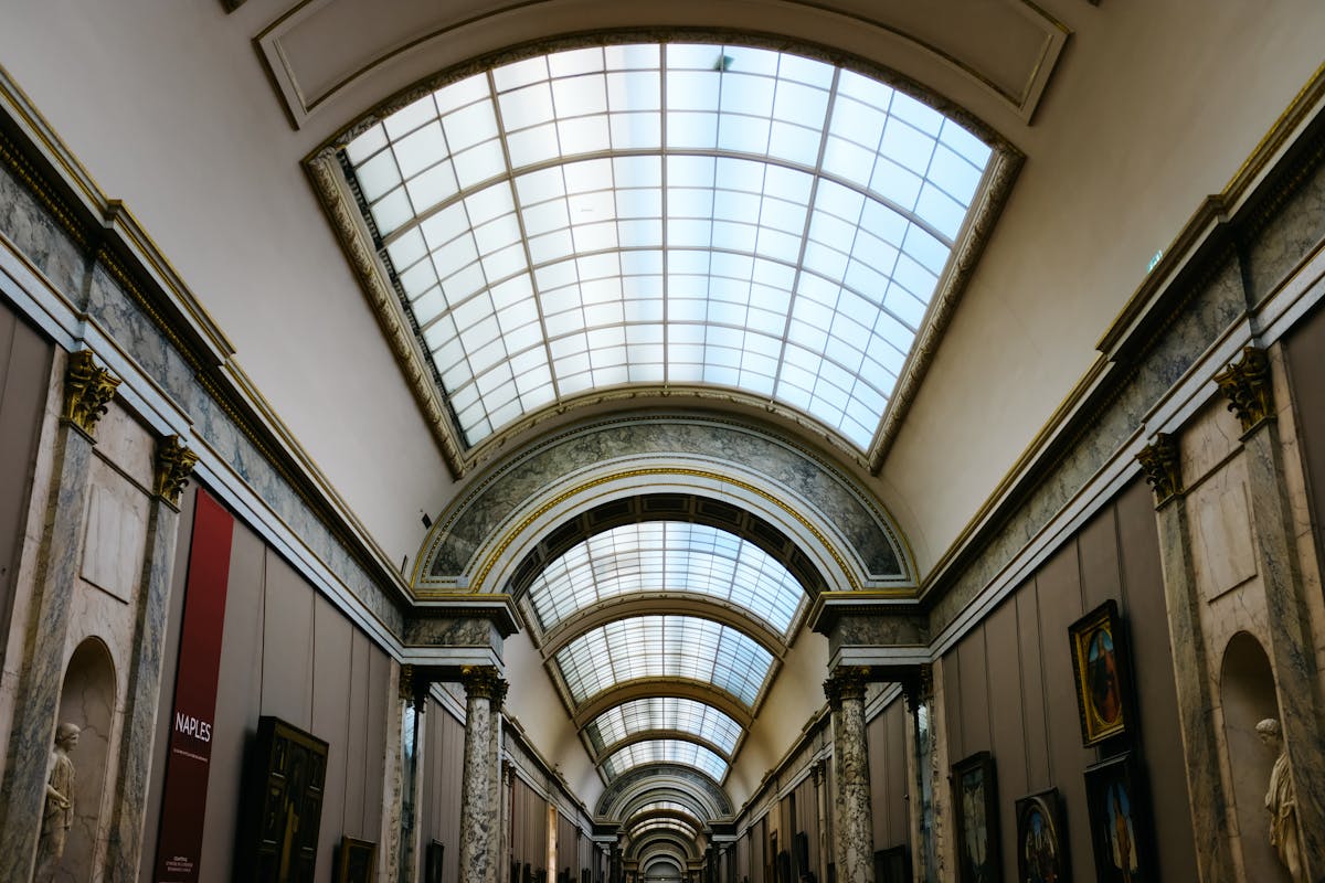 Grand glass-ceiling corridor inside a Paris museum