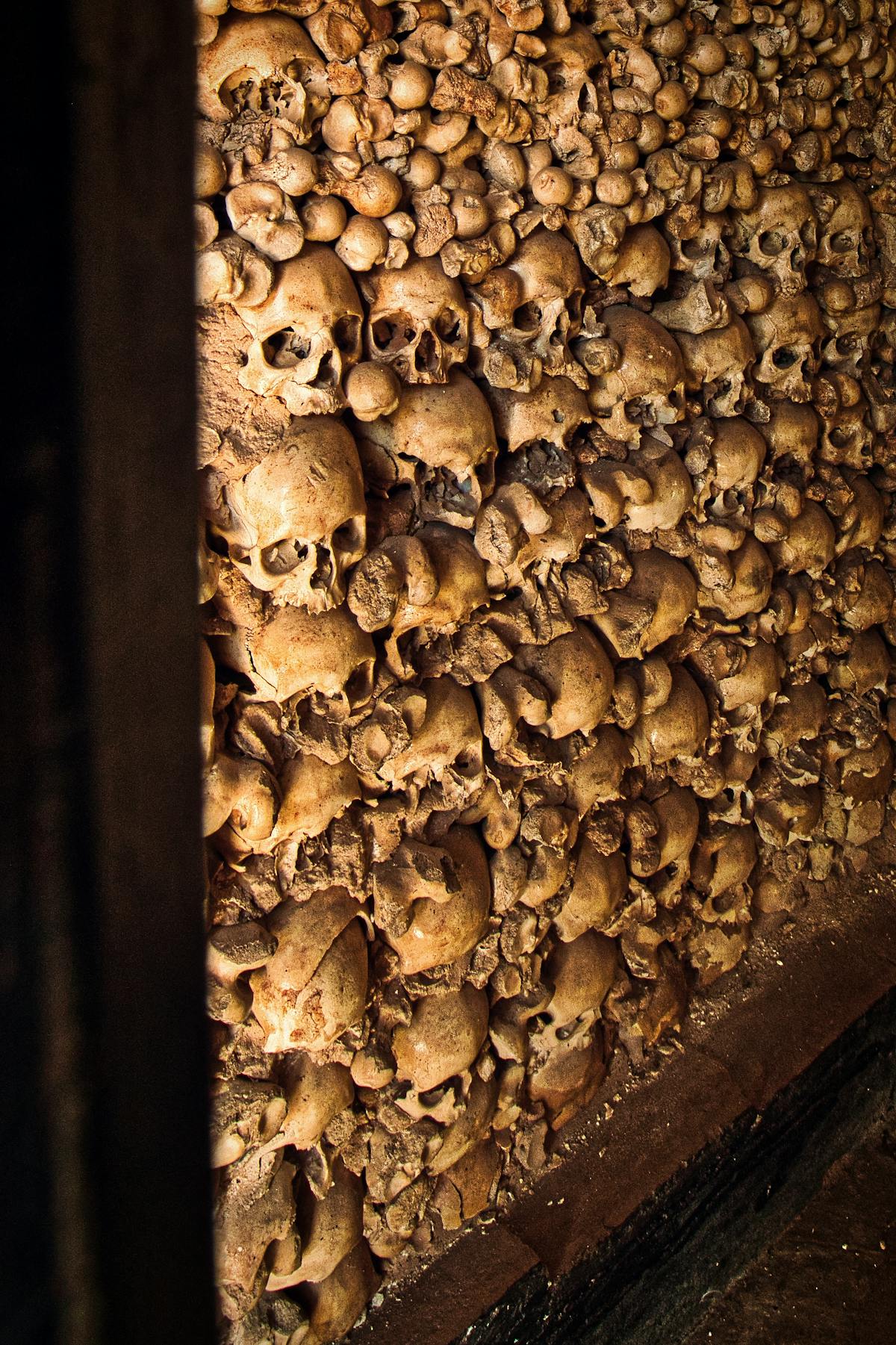 A detailed view of skulls embedded in the ossuary walls of an ancient catacomb