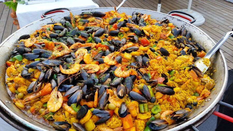 Close-up of traditional seafood paella cooking in a large outdoor pan