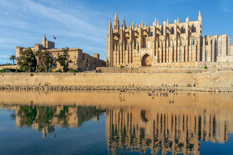 Palma Cathedral reflected in calm water on a sunny day