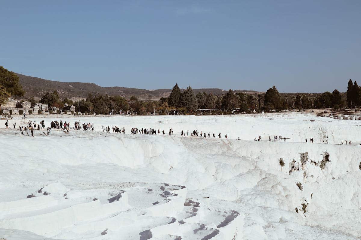 Visitors walking barefoot on the white calcium terraces of Pamukkale