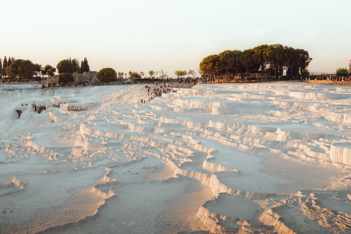 Pamukkale travertine terraces glowing at sunset with warm golden light