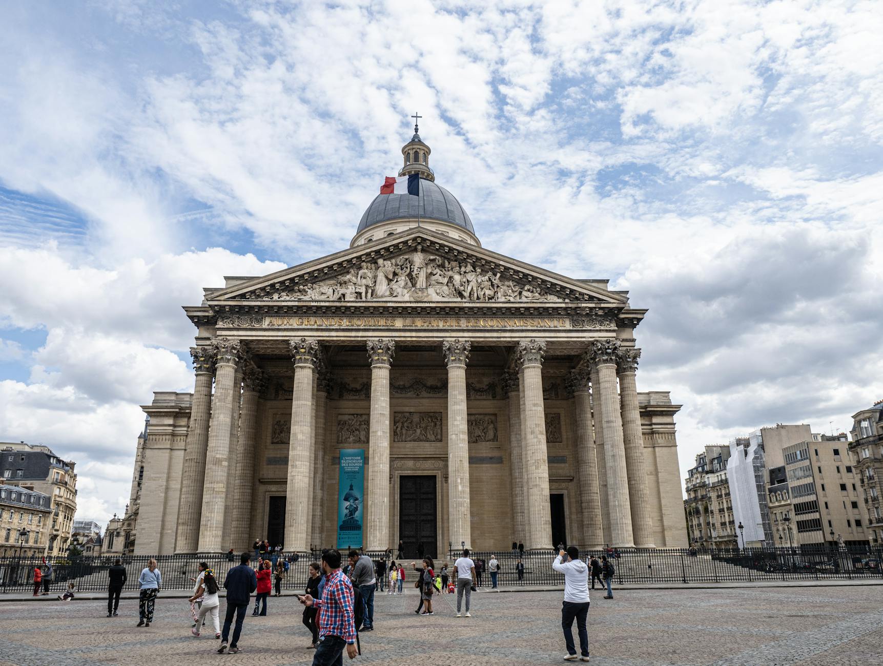 The Pantheon in Paris on a cloudy day with visitors in the foreground