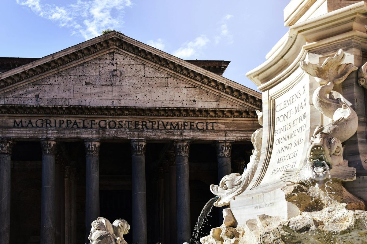 The Pantheon facade and fountain details under a clear sky in Rome