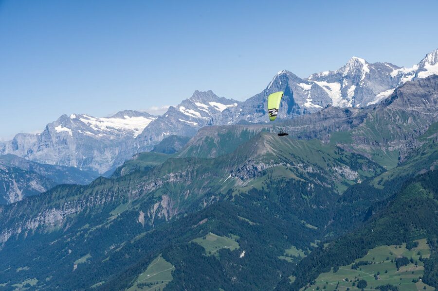 Paraglider on an adventure flight over Swiss Alps in summer