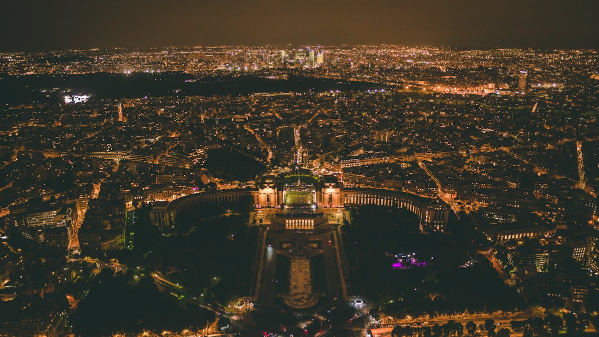 Paris city lights seen from above at night with the skyline stretching into the distance