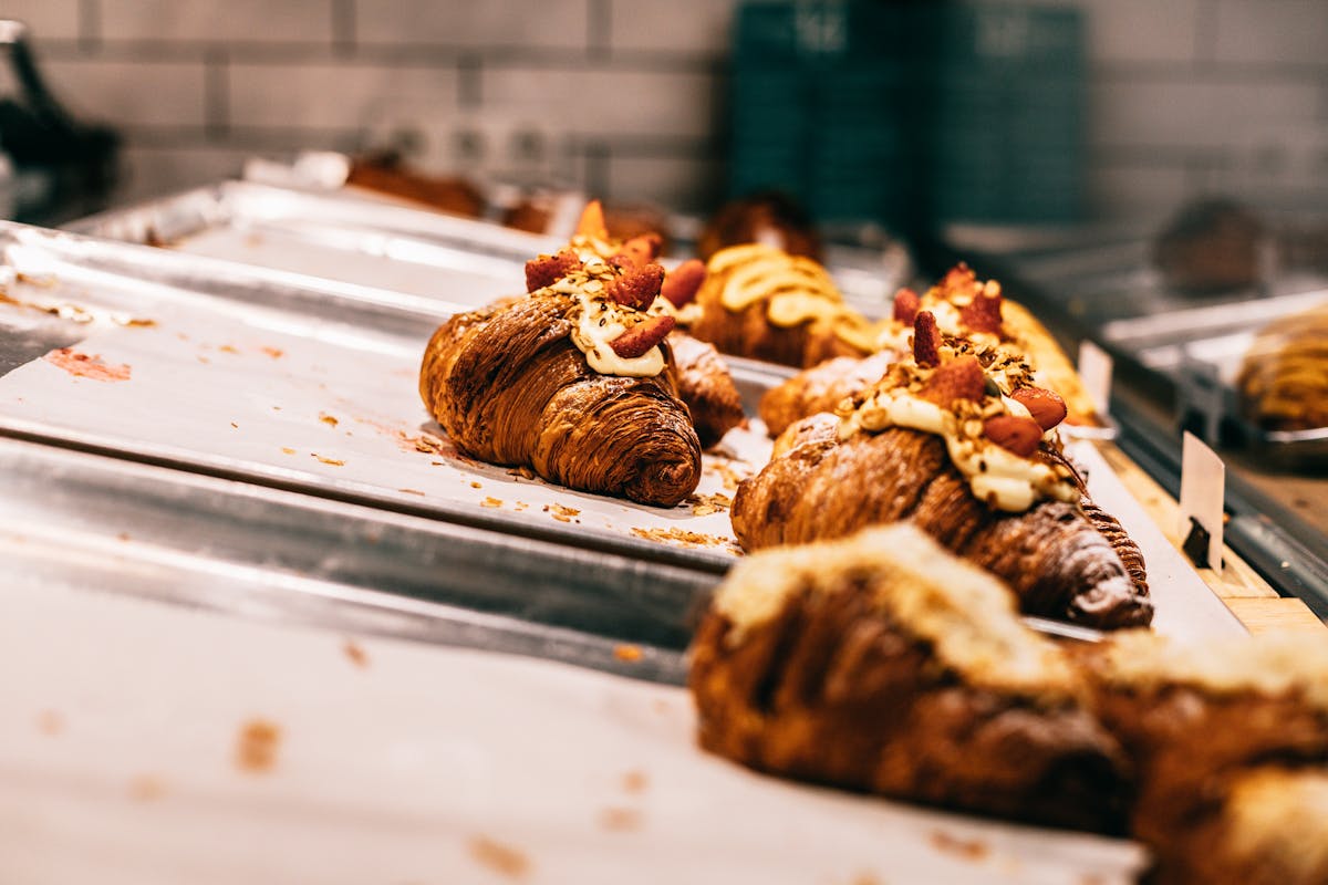 Fresh baked croissants on metal trays in a modern bakery