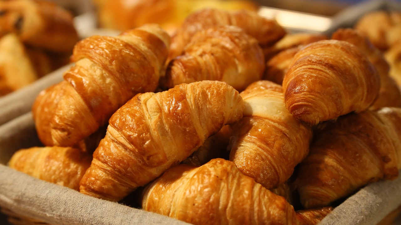 Fresh buttery croissants arranged on a baking tray