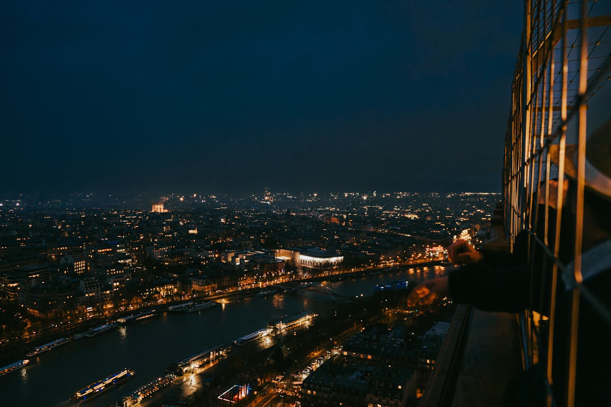 Night aerial view of Paris showing the illuminated Eiffel Tower and city lights