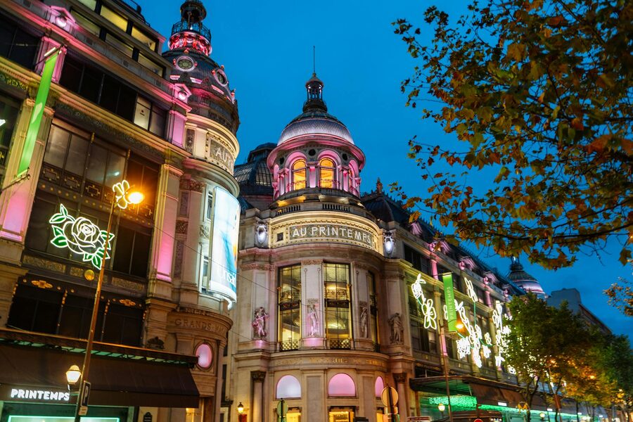 Illuminated Haussmann architecture along a Paris boulevard at night