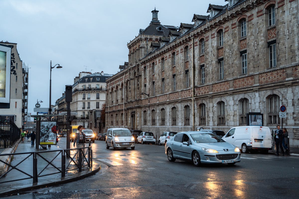 Wet street with classic Parisian architecture during a rainy evening