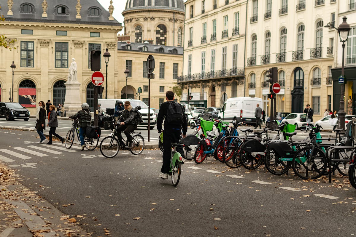 Cyclists and pedestrians on a Paris street with historic buildings