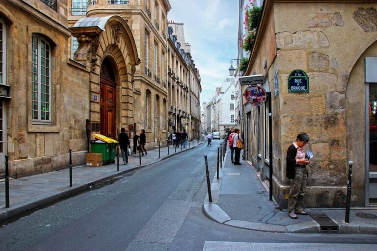 Narrow street in Le Marais Paris with classic architecture and local shops