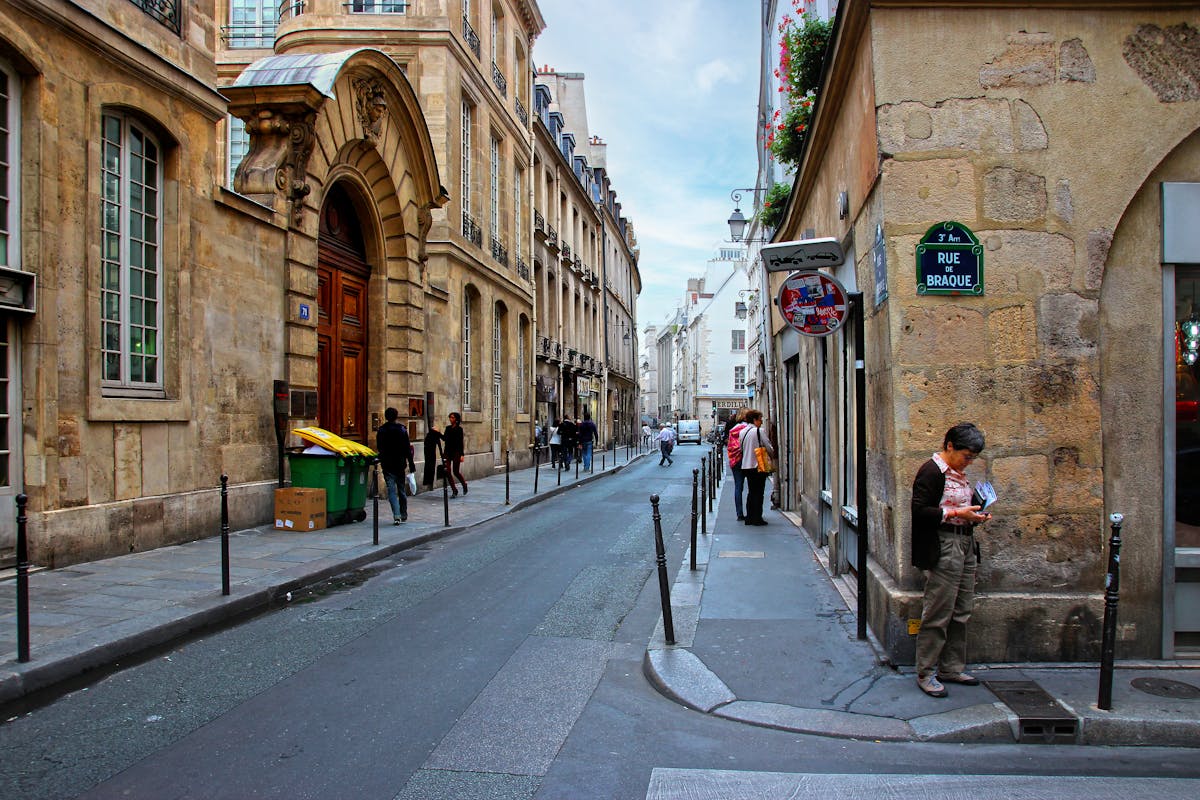 Narrow street in Le Marais Paris with classic architecture and local shops
