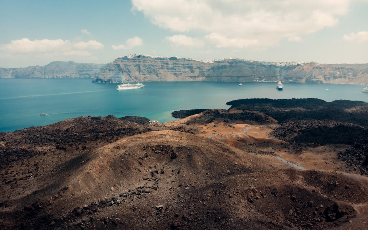 Aerial view of Santorini caldera with ships anchored in deep blue water