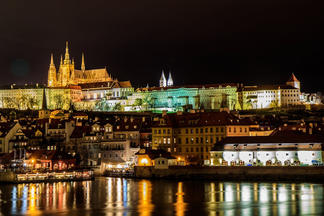 Prague Castle illuminated at night reflecting in the Vltava River