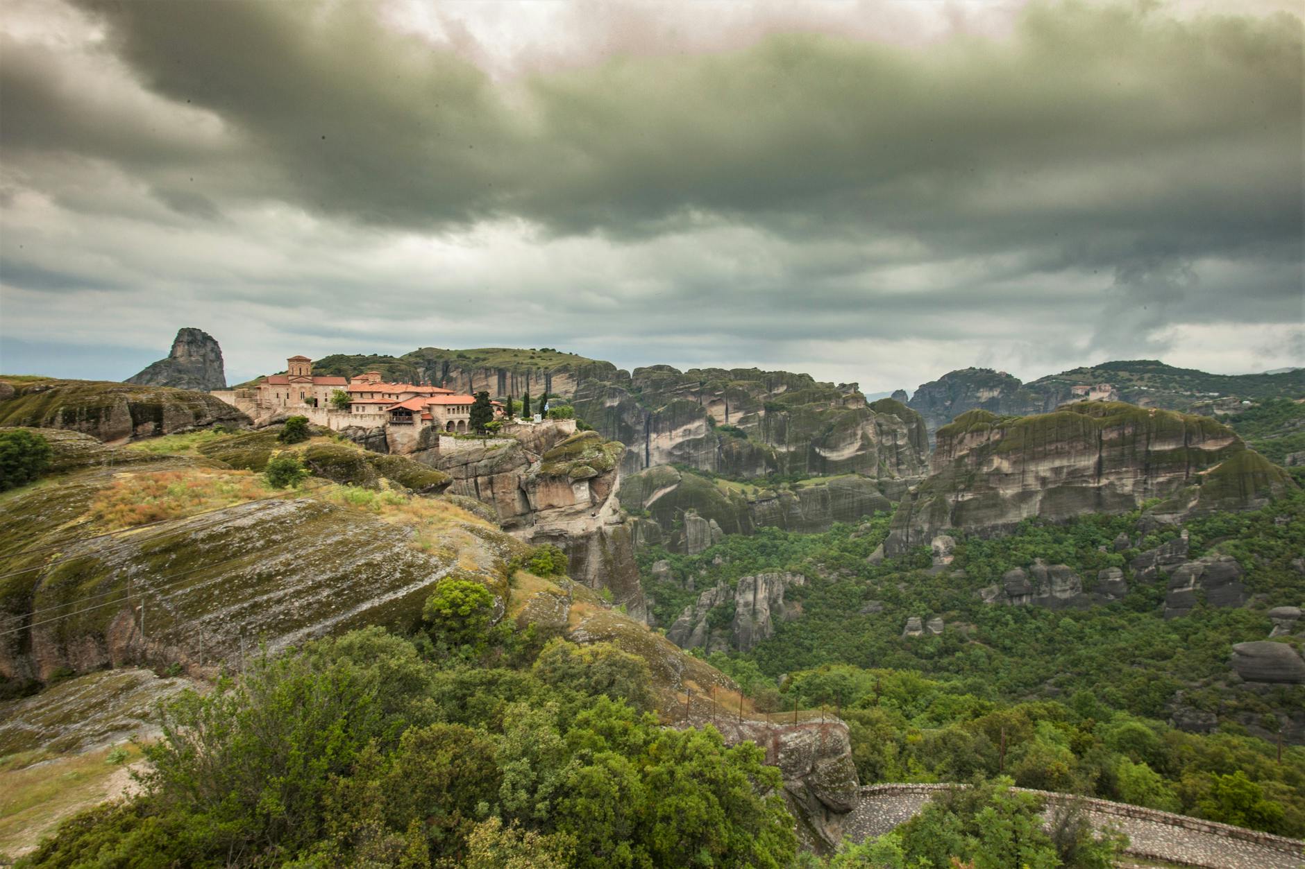 Aerial perspective of Meteora rock formations and a monastery from above in Kalambaka Greece