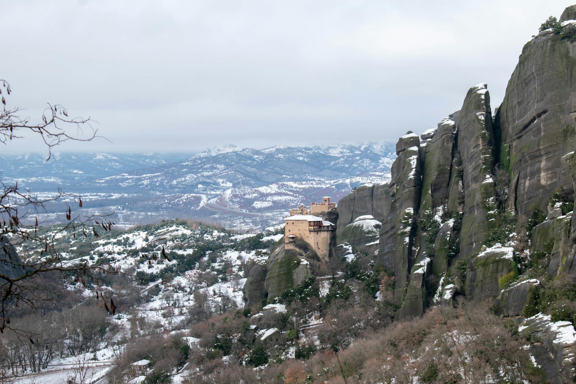 Stunning winter landscape of Meteora monastery perched on rocky cliffs covered in snow in Greece
