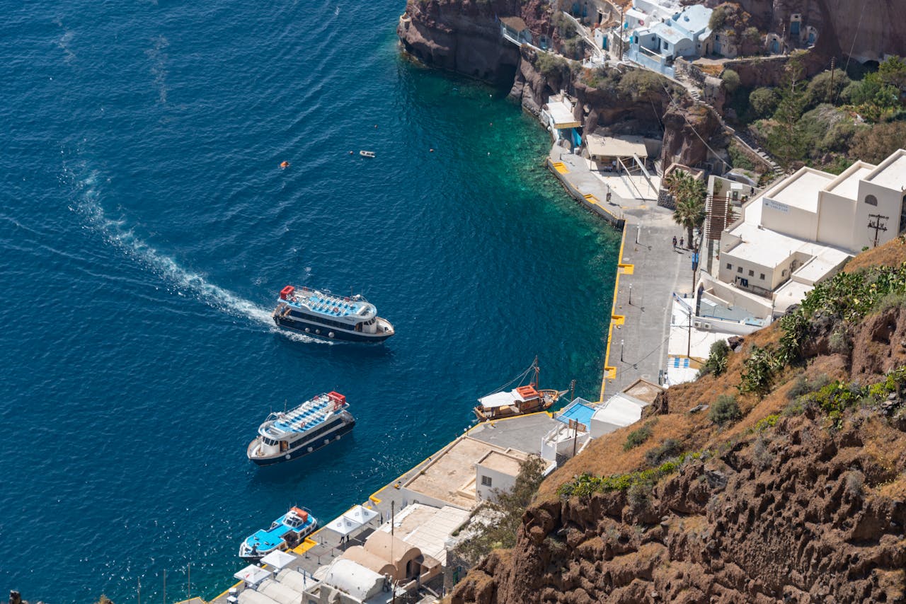 Old harbor of Fira with boats and bright blue water