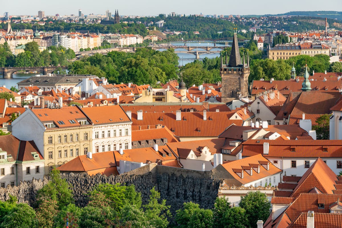 Aerial view of Prague showing red rooftops, Gothic architecture, and the Vltava River