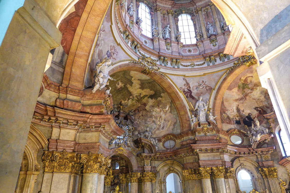 Intricate Baroque dome with frescoes and golden details in St Nicholas Church Prague